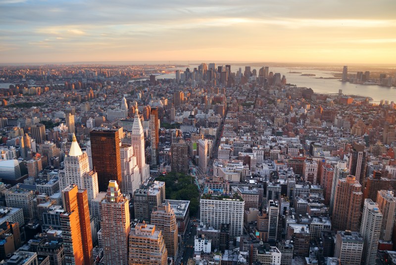 New York City Manhattan sunset skyline aerial view with office building skyscrapers and Hudson River.