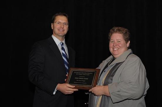 Foss Creek Court in Healdsburg, Calif., which was developed by Eden Housing, Inc., took the top honor in the rural category. Andrea Papanastassiou, director of real estate development at Eden Housing, Inc., accepts the award from David Leopold, senior vice president of Bank of America Merrill Lynch.