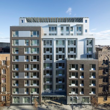 Designed by Magnusson Architecture and Planning, the 10-story building is divided into three smaller masses, two separate brick sections and a main body, slightly set back, clad in metal.