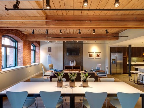 The development includes a 15,000-square-foot community room with a kitchen and entertainment space, fitness facilities, a movie theater, and an outdoor patio. Many of the historic features were restored, including high ceilings, large windows, and exposed brick.