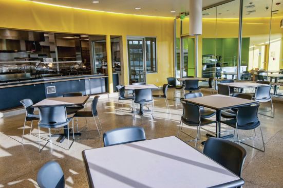 The ground floor features retail and community spaces, including a computer lab, a cafe, and a commercial kitchen for residents.